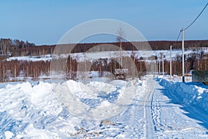 Piles of snow after the work of a tractor to clear rural roads in winter the consequences of heavy snowfall