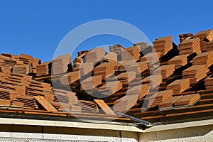 A house under construction with stacks of tile shingles on the roof. photo