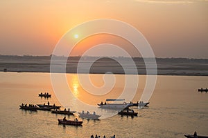 Pilgrims on boat floating on the waters of sacred river Ganges early morning.