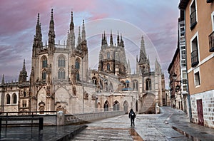 Pilgrims walking the Camino de Santiago, passing by the cathedral in the city of Burgos, Way of Saint James