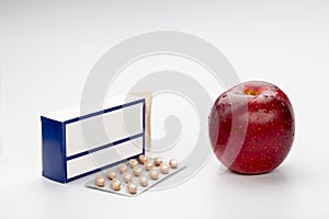 Pill blisters pack box and red apple