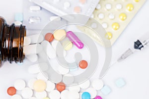 Pill bottle spilling out. colorful pills on to surface tablets background.