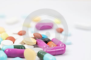 Pill bottle spilling out. colorful pills on to surface tablets background.