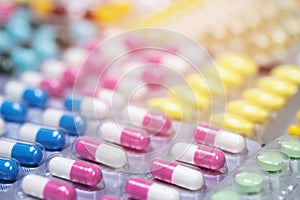 Pill bottle spilling out. colorful pills on to surface tablets background.