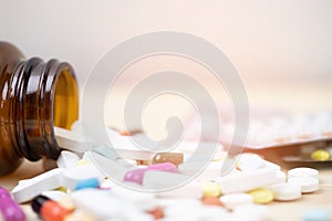 Pill bottle spilling out. colorful pills on to surface tablets on a table wooden background. top view. drug medical