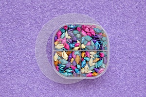 A pill box with colored shells instead of pills. View from above. The concept of healing with the help of the sea and