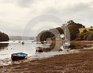 Boats at low tide in idyllic Cornish creek photo