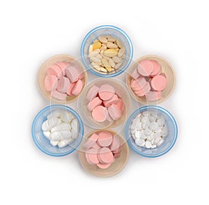 Pill cups filled with tablets and pills Isolated white background