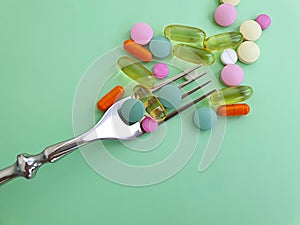 Pill, fork on colored background healthcare analgesic