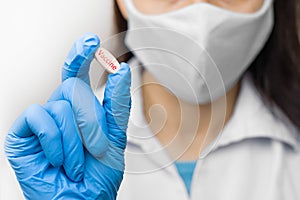 A pill in hand in blue gloves. Female is holding a vaccine against coronavirus,2019-nCoV, SARS-nCov, COVID-2019 outbreaking