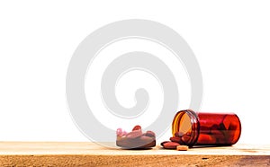 the Pill spilling out of brown color pill bottle isolated on woo