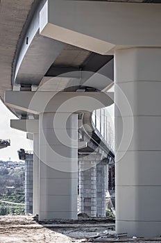 Pillar of bridge. Underside of an elevated roads. Gray pillars support the weight of the structure. Vital part of