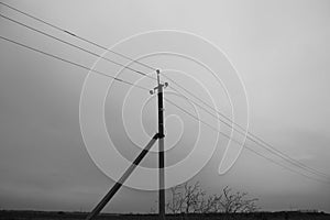 Pillar with electric wires in dark fog, gloomy landscape