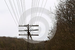 Pillar with lots of electric wires against sky