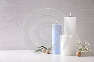 Pillar wax candles burning on table