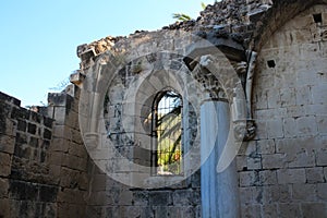 The pillared room of Bellapais Abbey, where meetings were once held, with a column and a barred window. White Abbey, the Abbey of