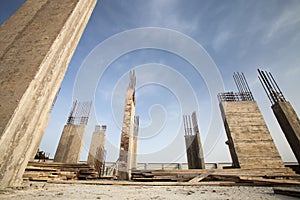 Pillars of a building in the making against blue sky