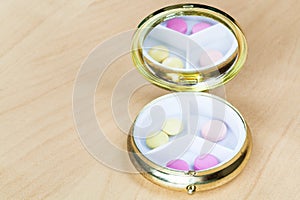 Pillbox with mirror with pink and yellow pills