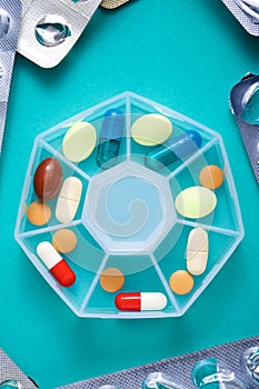 Pillbox with pills and capsules on a tabletop