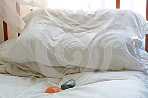 Pillow on bed with healing stones