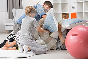 Pillow fight between father and children