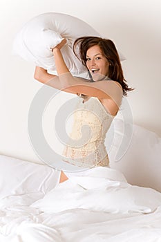 Pillow fight - young woman in bed