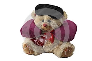 The pillow for neck and mask for eye are put on a toy bear. Sleep accessories for traveling. Isolated on a white background.