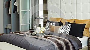 Pillows and cushions in white, beige brown and black color tone on bed and wardrobe in modern luxury bedroom