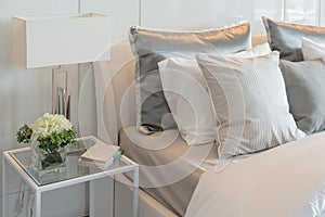 Pillows set on bed with vase of flower in luxury bedroom