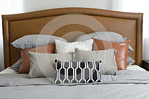 Pillows setting on bed with brown leather headboard