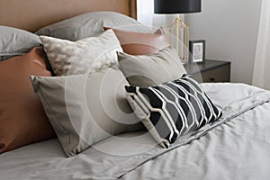 Pillows setting on bed with brown leather headboard