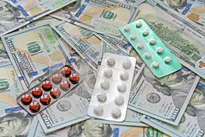 Pills on 100 dollar money. Medicine expenses. High costs of expensive medication concept