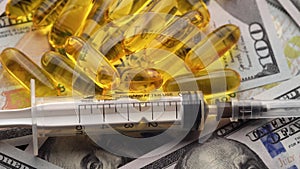 Pills, ampoules and syringes rotating on money - healthcare cost concept. Close-up