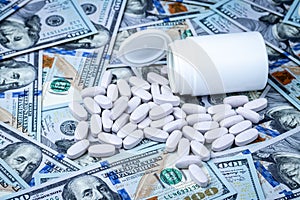 Pills on the background of hundred-dollar bills