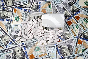 Pills on the background of hundred-dollar bills