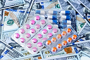 Pills on the background of hundred-dollar bills