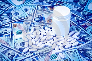 Pills on the background of hundred-dollar bills. The concept of the expensive cost of healthcare or financing medicine. White
