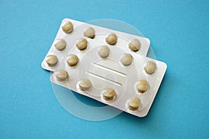 Pills in blister packs, vitamines. Pharmaceuticals antibiotics pills medicine on blue background. Pharmaceutical industry concept.