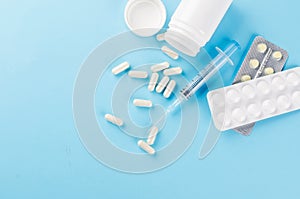 pills, blisters, syringe on a blue background