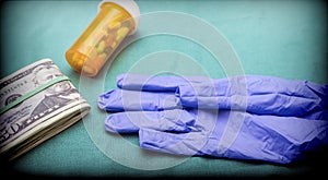 Pills bottle along with glove of blue latex