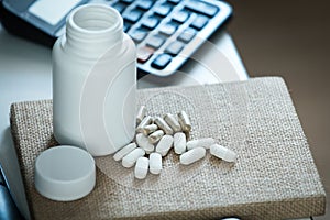 Pills and bottle on notebook in office desk