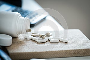 Pills and bottle on notebook in office desk