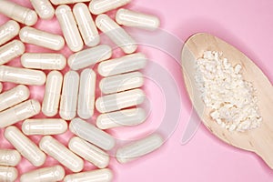 Pills capsules with colostrum, on a pink background