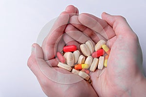 pills and capsules in hand on white background