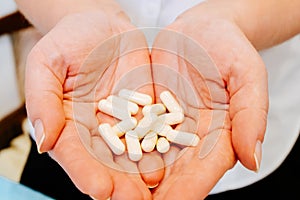 Pills and capsules in the hands of a beautiful female doctor, it is possible to use illegal drugs like drugs and potent substances