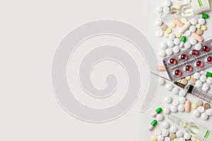 Pills capsules and syringe on white background