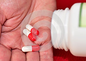 Pills in capsules in woomen hand. Medicine grade pharmaceutical tablets. Medical pill for maintaining and improving health.