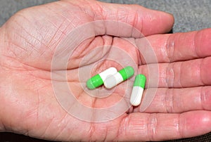 Pills in capsules in woomen hand. Medicine grade pharmaceutical tablets. Medical pill for maintaining and improving health.