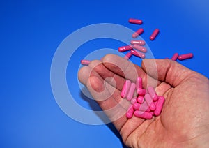 Pills in capsules in woomen hand. Medicine grade pharmaceutical tablets. Medical pill for maintaining and improving health.