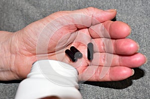 Pills in capsules in woomen hand. Medicine grade pharmaceutical tablets. Medical pill for maintaining and improving health.